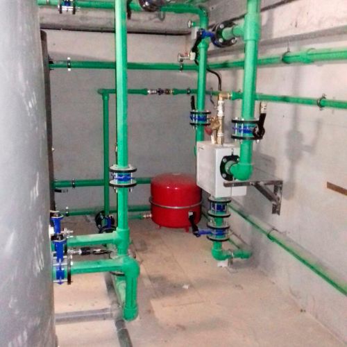 Interior de sótano con tubos de fontanería de color verde